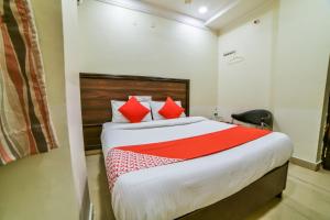 a bedroom with a large bed with red pillows at OYO Surya Teja Residency in Khammam
