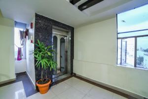 une chambre avec une plante et une fenêtre dans l'établissement OYO Surya Teja Residency, à Khammam