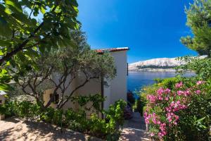 een huis met uitzicht op het water en de bloemen bij Apartments in Baska - Insel Krk 42194 in Baška