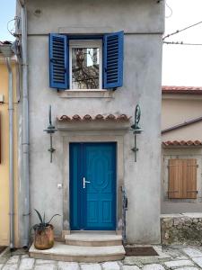 a building with a blue door and a window at Apartments in Baska - Insel Krk 41026 in Baška