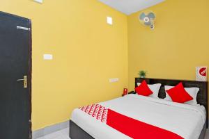 a bedroom with a bed with red and white pillows at OYO Seven Inn in Bhubaneshwar