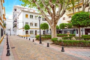a cobblestone street in a city with trees and buildings at Rosa Marbella in Marbella