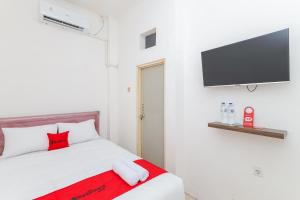 西冷的住宿－RedDoorz near Pasar Lama Serang，一间卧室配有一张床和一台平面电视