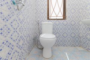 a bathroom with a white toilet and a window at RedDoorz near Pasar Lama Serang in Serang