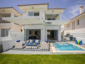 a villa with a swimming pool and a house at Protaras Seafront Villa Sirina Pearl in Protaras