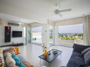 a living room with a couch and a table at Protaras Seafront Villa Sirina Pearl in Protaras