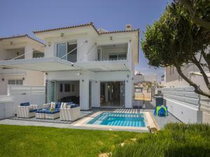 a villa with a swimming pool and a house at Protaras Seafront Villa Sirina Pearl in Protaras