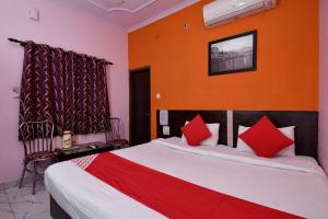 1 dormitorio con 1 cama grande con almohadas rojas en Super OYO Hotel Haveli Inn1 en Varanasi