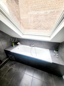 ブリュッセルにあるCity Brussels Apartmentsの大きな窓のある客室で、大きなバスタブが備わります。 +14枚の写真