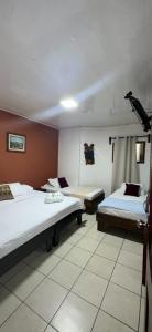 a hotel room with two beds and a camera at Hotel Pacande B&B in Alajuela