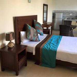 a bedroom with a large bed and a table with a lamp at Fortuna Beach in Flic-en-Flac