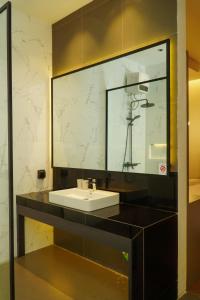 AKSHAYA VILLA SUKABUMI في سوكابومي: حمام مع حوض ومرآة