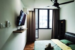 - une chambre avec un lit et une télévision dans l'établissement Jeff and Ricky Homestay 2 @Vivacity Megamall, à Kampong Tabuan