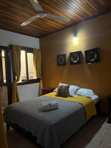 a bedroom with a bed with yellow sheets and a ceiling at Hotel Pacande B&B in Alajuela