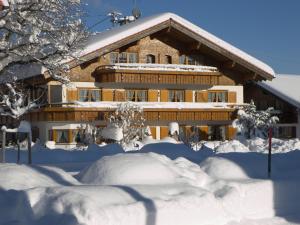 a building covered in snow with a pile of snow at Landhaus Aigner-Vogler in Fischen