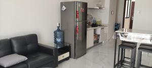 - un salon avec un canapé et un réfrigérateur dans l'établissement BSDE 2BR Skyhouse Jervois, à Cilenggang