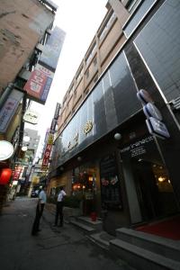 Dois homens à porta de uma loja numa rua da cidade. em Star Guest House em Seul