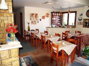 a restaurant with tables and chairs in a room at Pension Posidon in Olympia