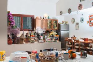 a kitchen with a table and a refrigerator at Il Vecchioliveto di Ornella in Marrùbiu