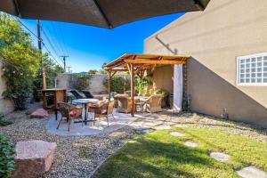 百慕大沙丘A Royal Oasis in the Desert with pool, spa and Epic Game Room!的凉亭下有桌椅的露台