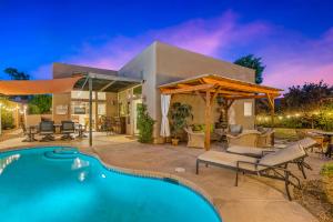 a house with a swimming pool and a patio at A Royal Oasis in the Desert with pool, spa and Epic Game Room! in Bermuda Dunes