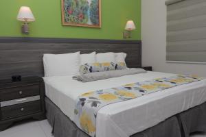 uma cama grande num quarto com paredes verdes em Kiskadee Korner em Port of Spain