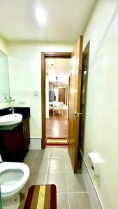 a bathroom with a sink and a toilet and a table at BRENT RESIDENCES BAGUIO in Baguio