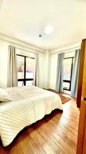 a bedroom with a large bed and windows at BRENT RESIDENCES BAGUIO in Baguio