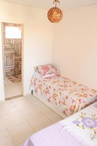 a bedroom with two beds and a chandelier at Casa de andar a 200m da areia Praia da Caueira SE in Praia Da Caueira