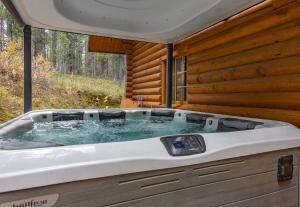 a bath tub in the back of a log cabin at Henrys Cast by KABINO Hot Tub Large Driveway PS4 Dog Friendly Fire Pit Fireplace in Island Park +33 photos