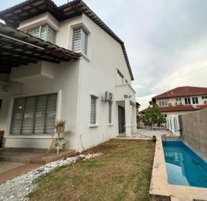 una casa blanca con piscina frente a ella en Icon BM Vacation Home with Water Fountain and Barbeque Area by ZamanJa, en Bukit Mertajam