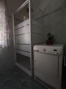 una lavanderia con frigorifero e lavatrice di Casa GAMAR a Palermo