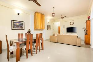 una sala da pranzo e un soggiorno con tavolo e divano. di Paradise Inn a Cochin