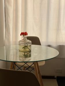 a glass table with a vase with a flower in it at Puruha Inn in Riobamba