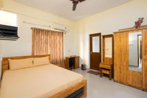 a bedroom with a bed and a dresser and a mirror at Paradise Inn in Cochin