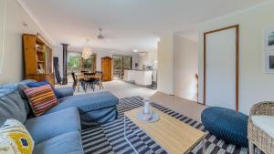 Una sala de estar con un sofá azul y una mesa. en Florida Trees, en Inverloch