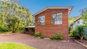 a wooden house with a driveway in front of it at Florida Tree's in Inverloch