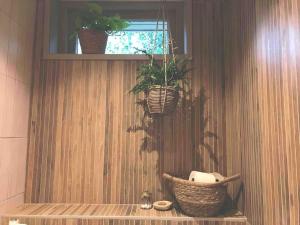 オッテルローにあるThe Forest Lodgeの木製の壁に鉢植えの植物2本が備わるバスルーム