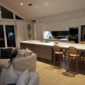 a kitchen with a couch and a table with chairs at Avoca Beach Seabreeze at Saltwater in Avoca Beach