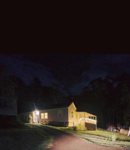 una casa con una luz en el costado de ella por la noche en Jo’s Farmhouse B&B, en Geeveston
