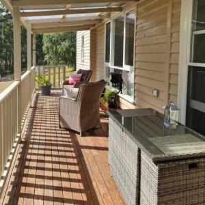 a patio with chairs and a table on a house at Jo’s Farmhouse B&B in Geeveston