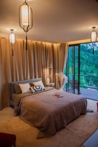 a bedroom with a large bed and a large window at Sunset Hilltop Ocean View 2bd House in Haad Tian