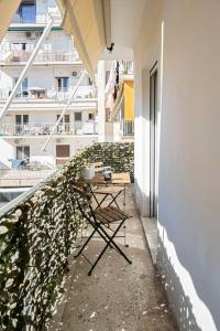 une table et une chaise sur le balcon d'un bâtiment dans l'établissement Filoxenia MG city center, à Athènes