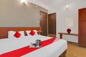 a hotel room with a large bed with red pillows at OYO Hotel Jayam Ooty Residency in Ooty