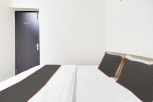 a bed in a room with a black door at Hotel Mk Grand in Patna