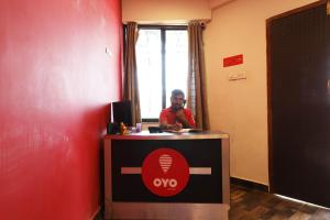 a man sitting at a desk in a room at OYO Prithvi Inn in Dhantoli