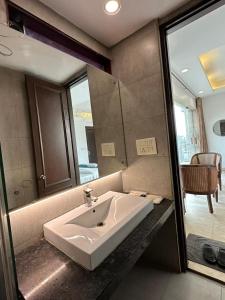 a bathroom with a white sink and a mirror at Hotel The Imperio in New Delhi