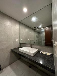 a bathroom with a sink and a large mirror at Hotel The Imperio in New Delhi