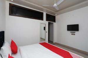 una camera con letto e TV a schermo piatto di Flagship Hotel Uk-07 a Rājpur