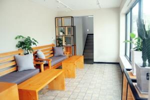 GongjuにあるEin Houseの木製ベンチ2台と鉢植えの植物が備わる部屋